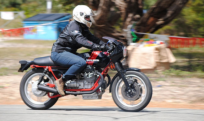 Antoinet roars
          up the hill on the Guzzi.