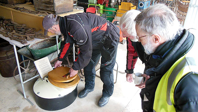 Wes demonstrating to Ian and Philip how to use an old
          toilet.