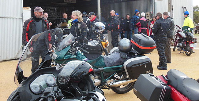 Mob milling outside shed.