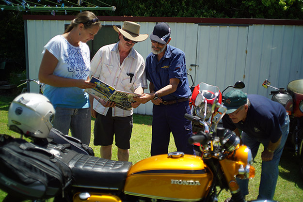 Antoinet, Colin and John checking out Old Bike
          Australasia magazine and Warwick checking out Johns Honda
          CB750.