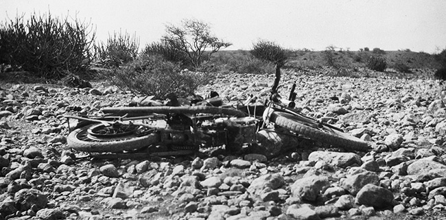 Crashed bike on rocky road.