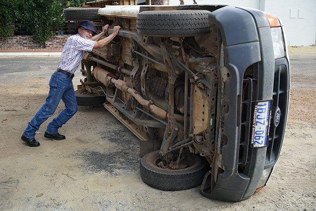 Club muscleman, Phillip, pushing over a car in Manjimup as part of his morning work-out.