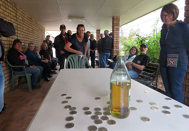 Antoinet showing her technique in throwing a 50c piece, as Raelene looks on.