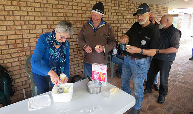 Wendy showing how to scoop ice cream, John looks like hes studying hard.