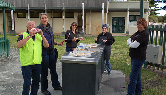 Ray about to eat the bun with Antoinet, Raelene, Trudy and Petra watching.