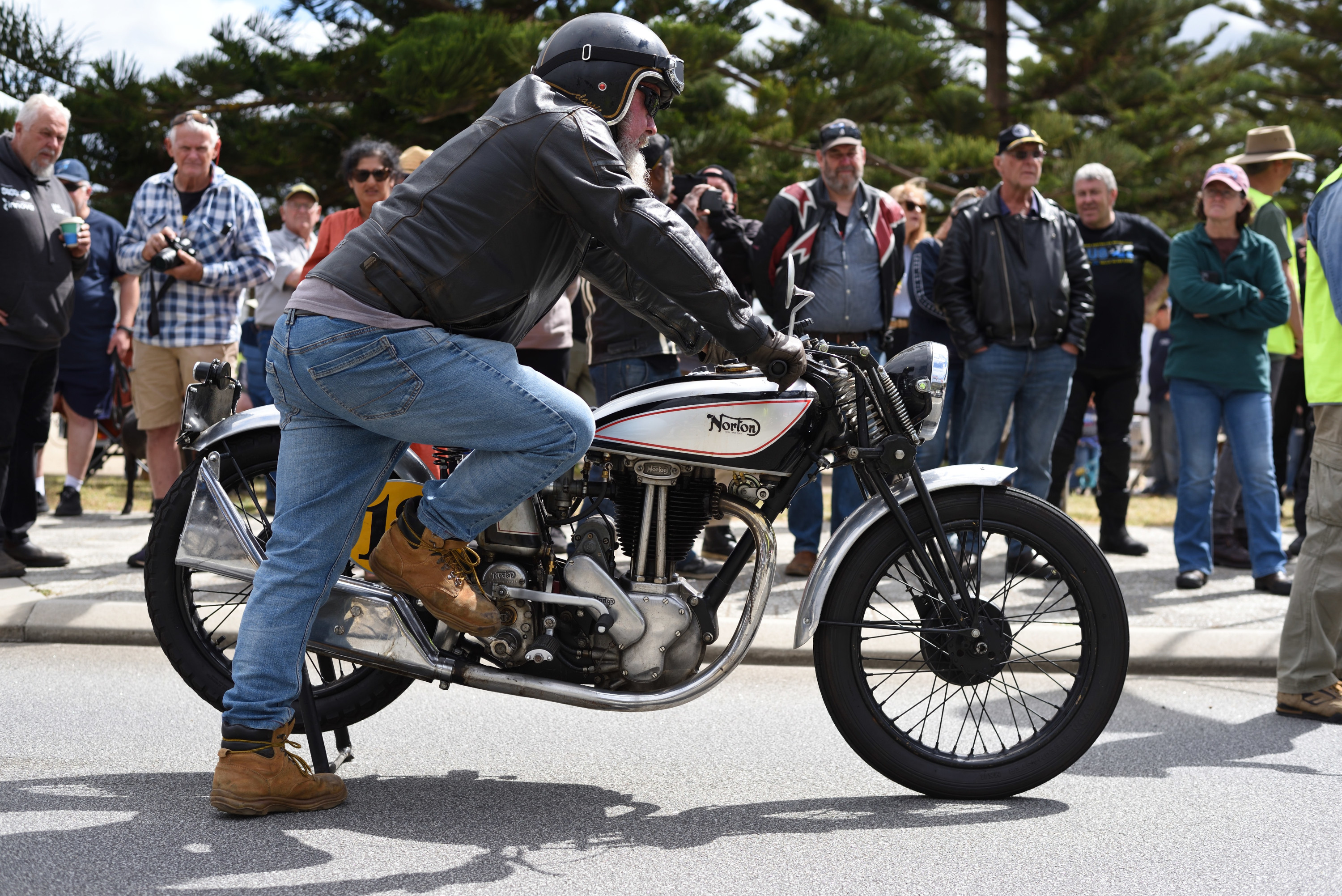 Kick-starting an old Norton with
        spectators watching.