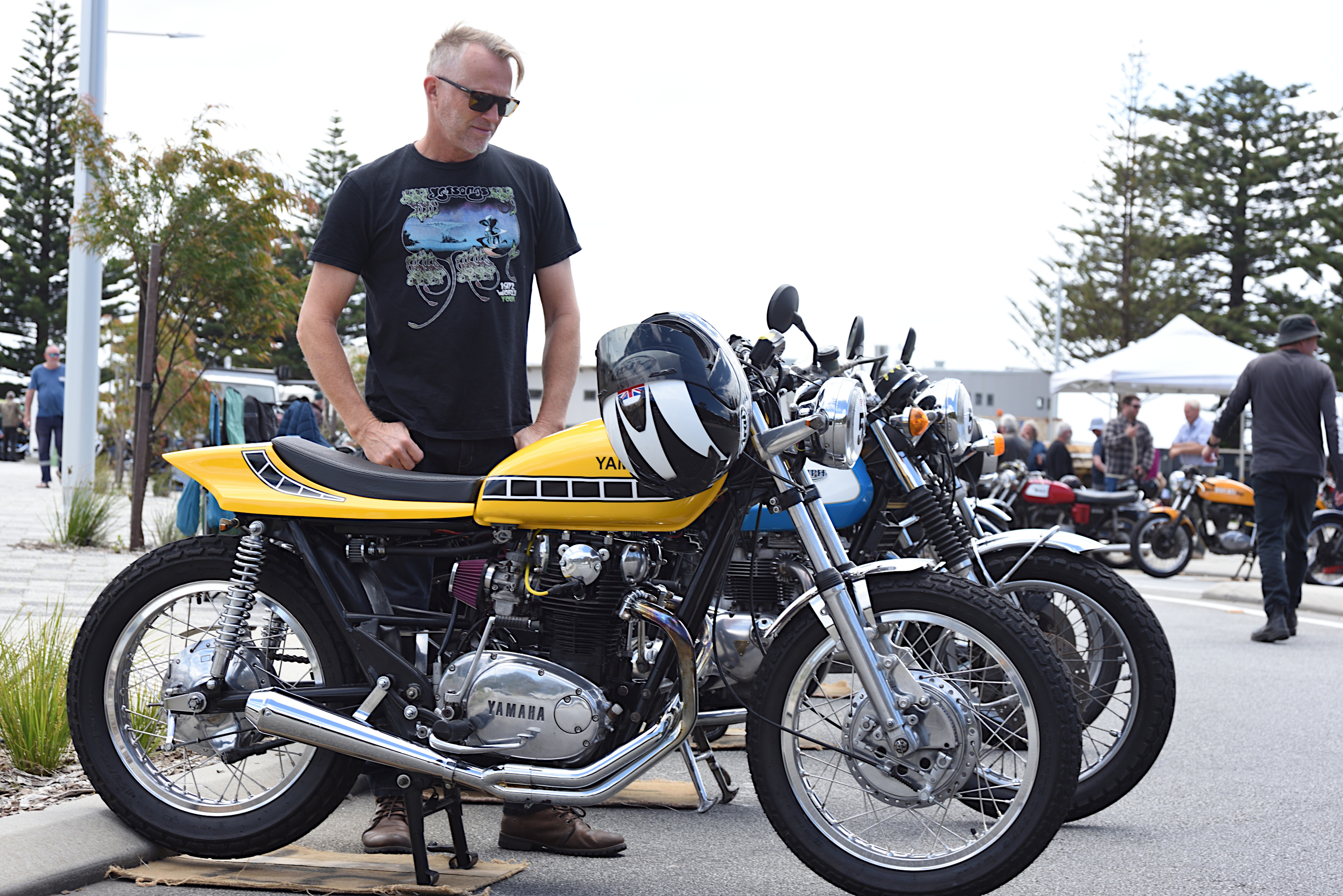 Man admiring a Kenny Roberts styled
        yellow and black Yamaha 650.